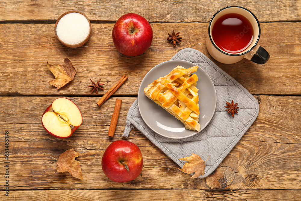 Plate with piece of delicious apple pie and cup of hot tea on wooden background