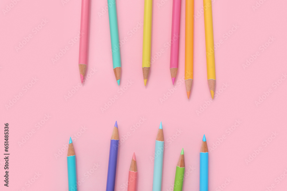 Many colorful pencils on pink background