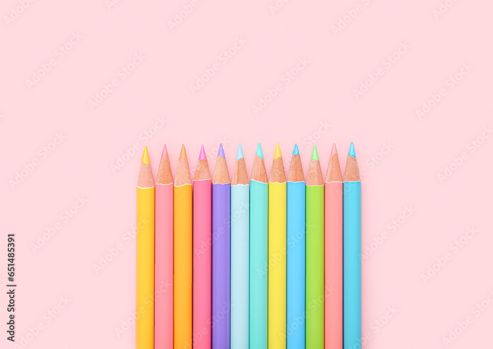 Many colorful pencils on pink background