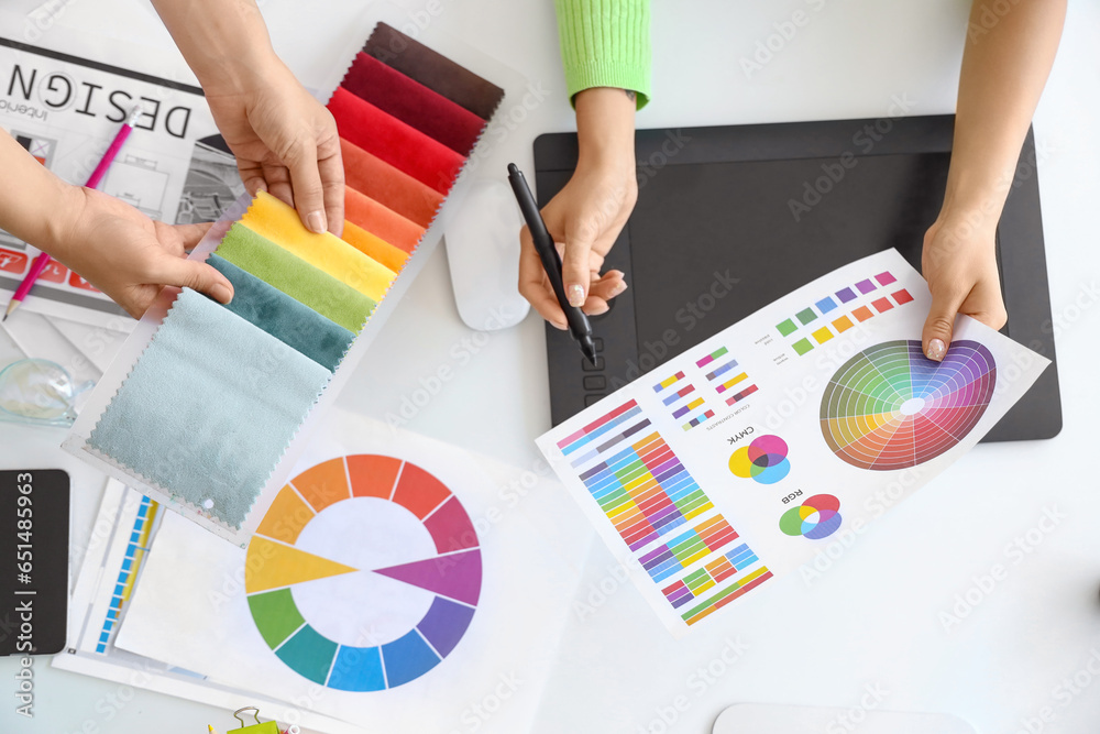 Female interior designers working at table in office, top view