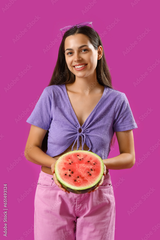 Beautiful young woman with half of fresh watermelon on purple background