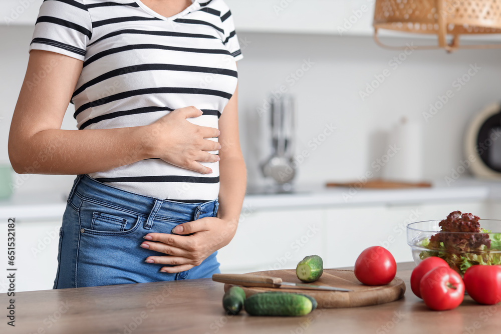 Young pregnant woman cooking in kitchen, closeup