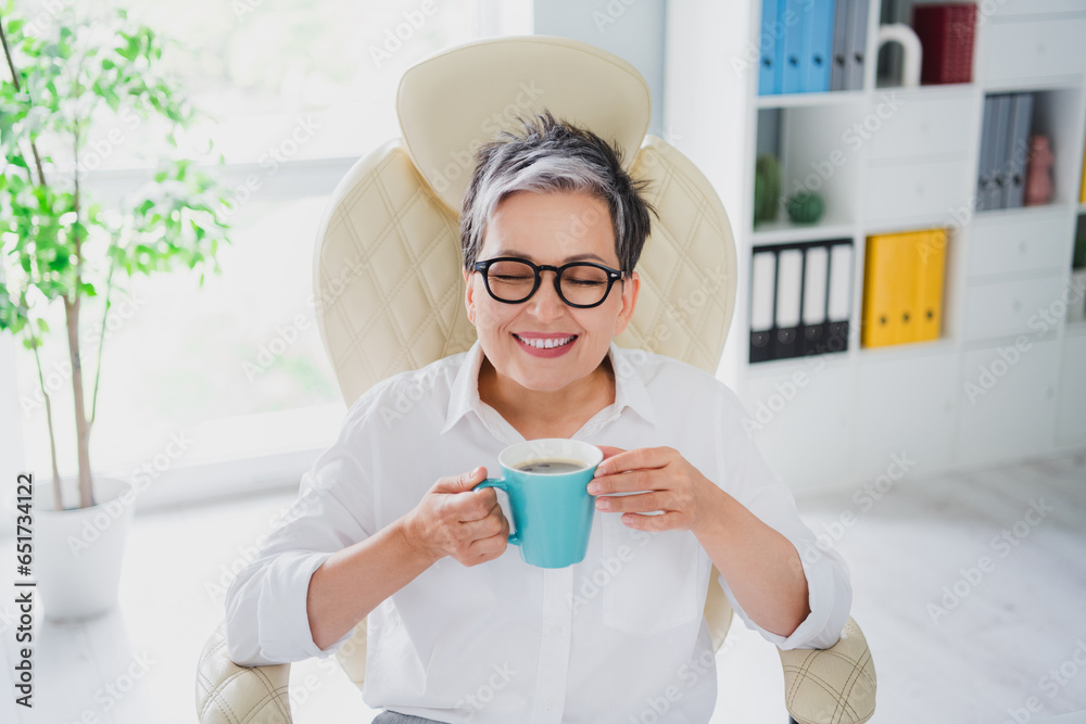 Daylight office view photo of pensioner woman successful business lady enjoy smell aroma morning espresso isolated indoors background