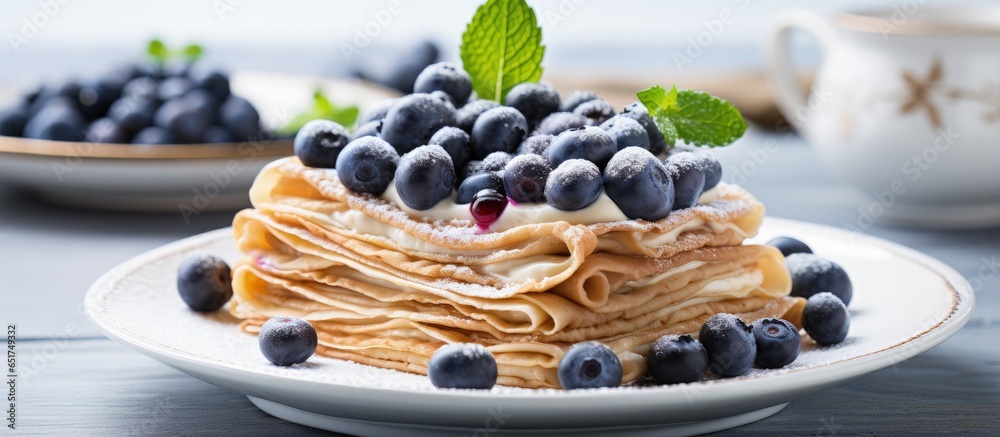 Vegan chickpea crepes with gluten free flour oat milk and blueberries on a wooden table