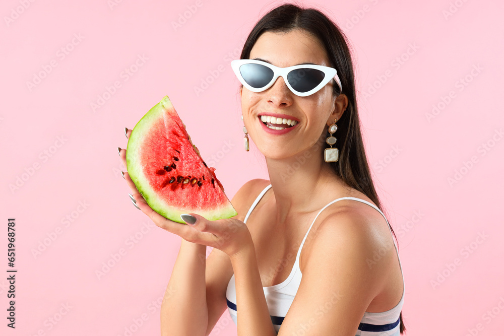 Young woman with fresh watermelon on pink background