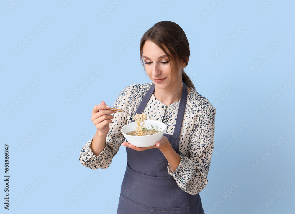 Young woman with chicken soup on blue background