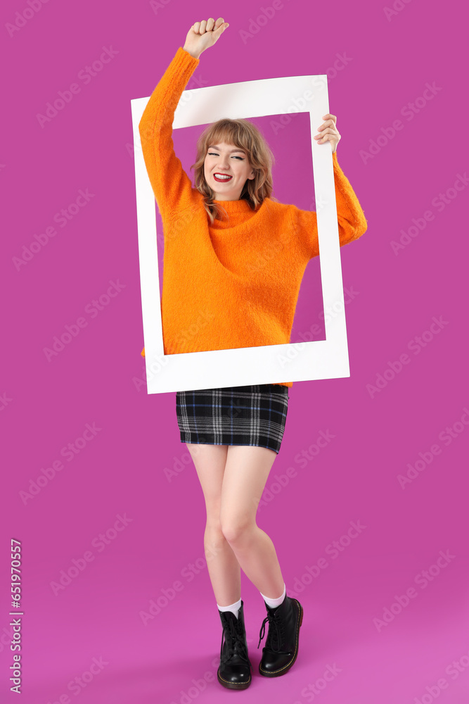 Young woman with frame on purple background