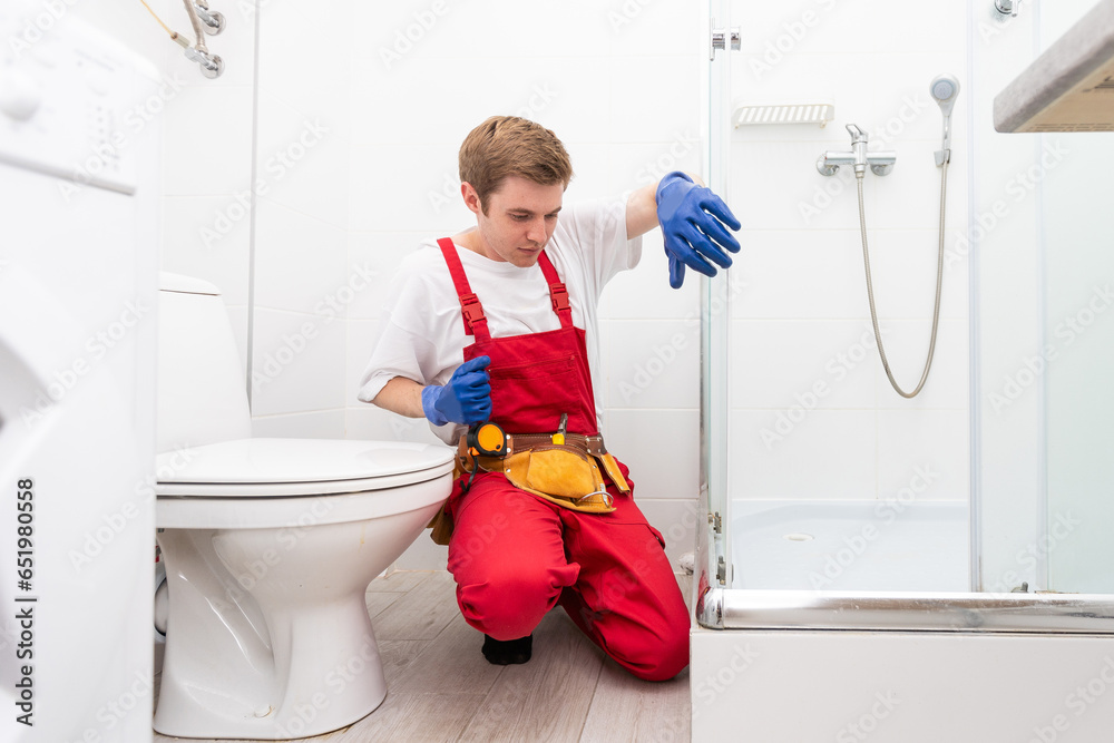 Plumber installing a shower cabin in bathroom