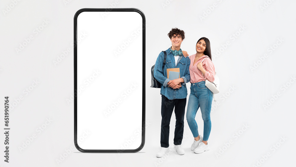 Students Couple Posing Near Large Smartphone Holding Backpacks, White Background