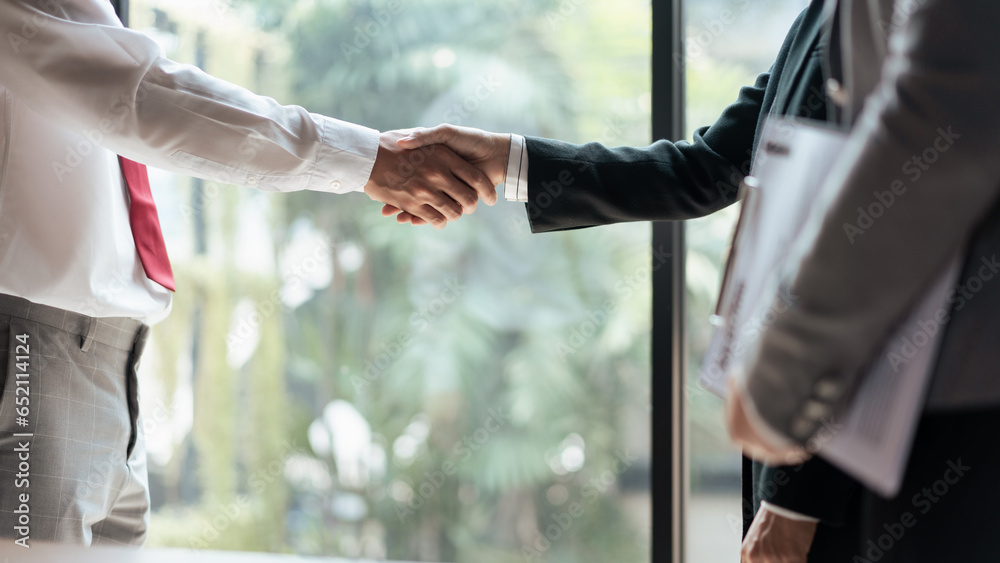 HR manager woman shaking hand with male candidate after successful job interview in office