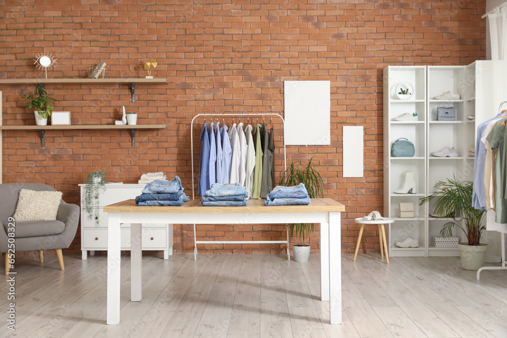 Table with stylish jeans pants in modern boutique