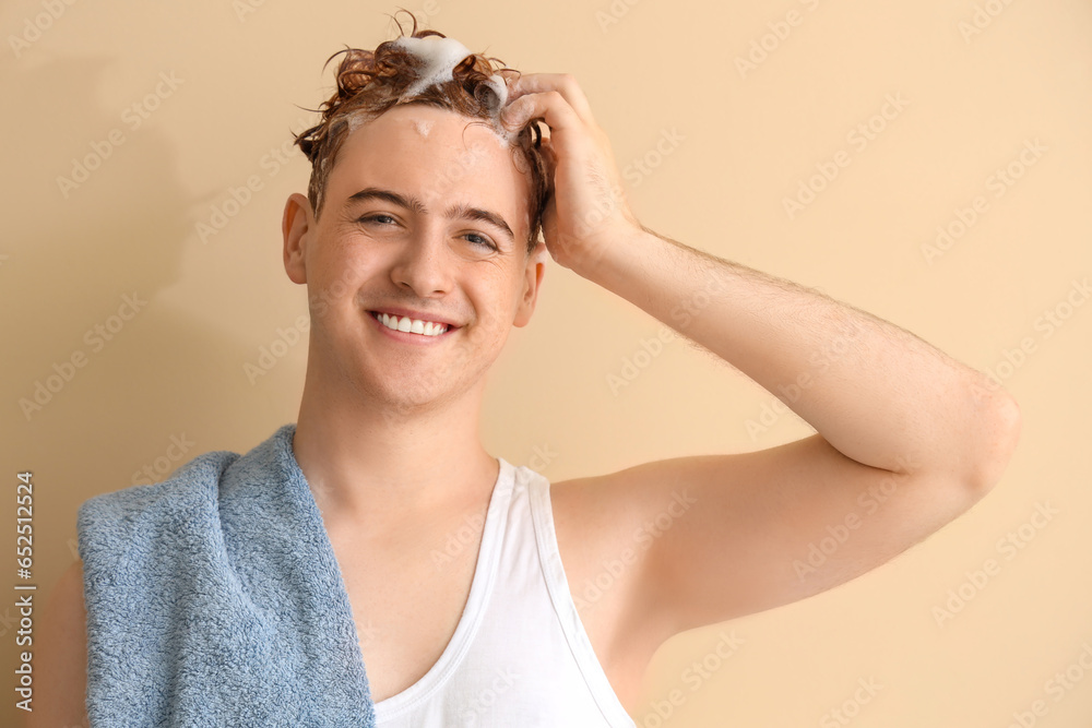 Young man with applied shampoo on his hair against beige background