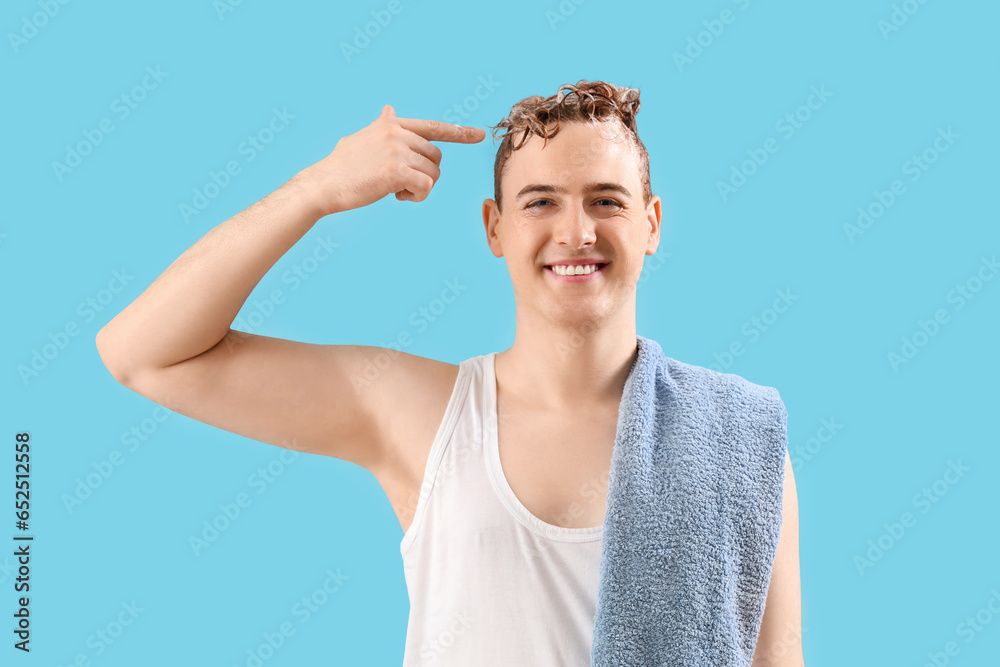 Young man with applied shampoo on his hair against light blue background