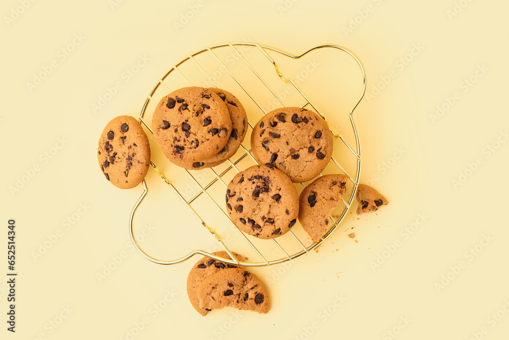 Grid of tasty cookies with chocolate chips on yellow background