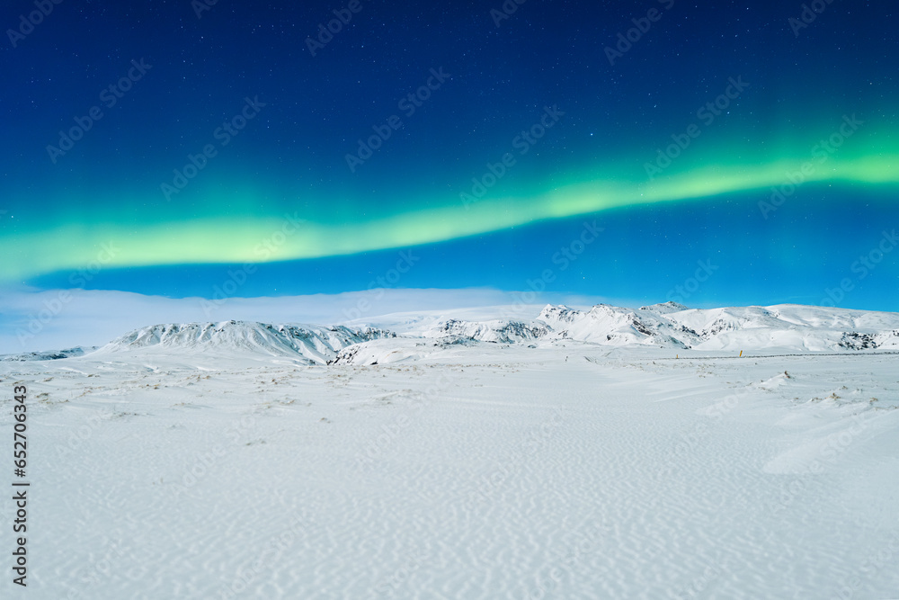 Aurora Borealis. Northern lights and clear skies. Nature. Scandinavian countries. Snow and ice on the mountains. Landscape in winter time. Photo for background and wallpaper.