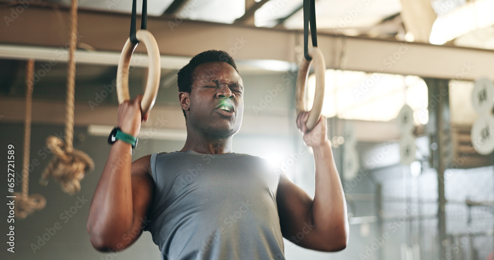 Sports, gymnastics and black man doing pull up exercise for arm muscle training or workout in gym. Fitness, bodybuilding and African male athlete doing an intense strength challenge in health center.