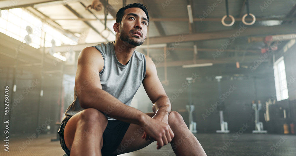 Fitness, breathing and sweating with a tired man in the gym, resting after an intense workout. Exercise, health and fatigue with a young athlete in recovery from training for sports or wellness