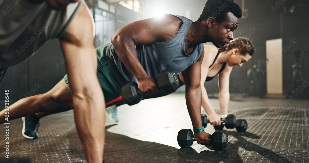 Gym group, dumbbell and rowing exercise for power, muscle challenge and action in workout class. Serious black man, strong bodybuilder and push up with heavy weights for fitness of healthy training