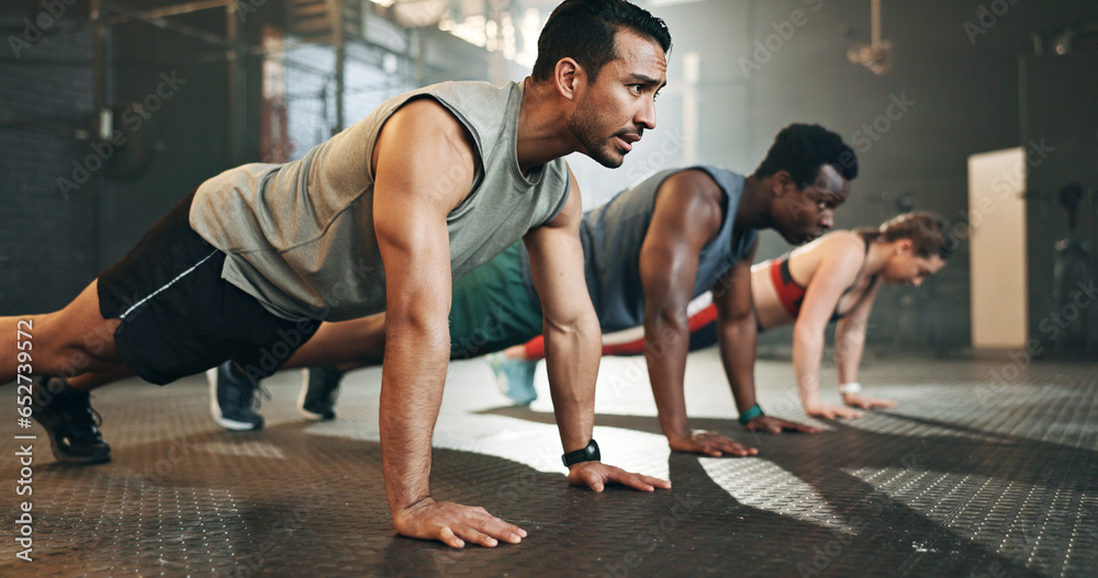 Gym, group fitness and push up exercise for power, sports challenge and muscle on ground. Serious asian man, bodybuilder and performance training on floor with friends, workout class or strong people