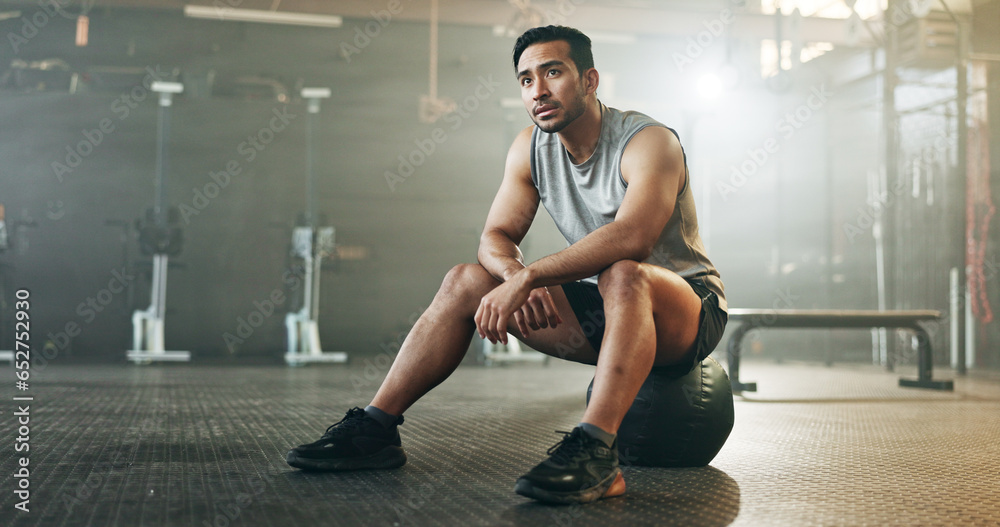 Fitness, breathing and sweating with a tired man in the gym, resting after an intense workout. Exercise, health and fatigue with a young athlete in recovery from training for sports or wellness