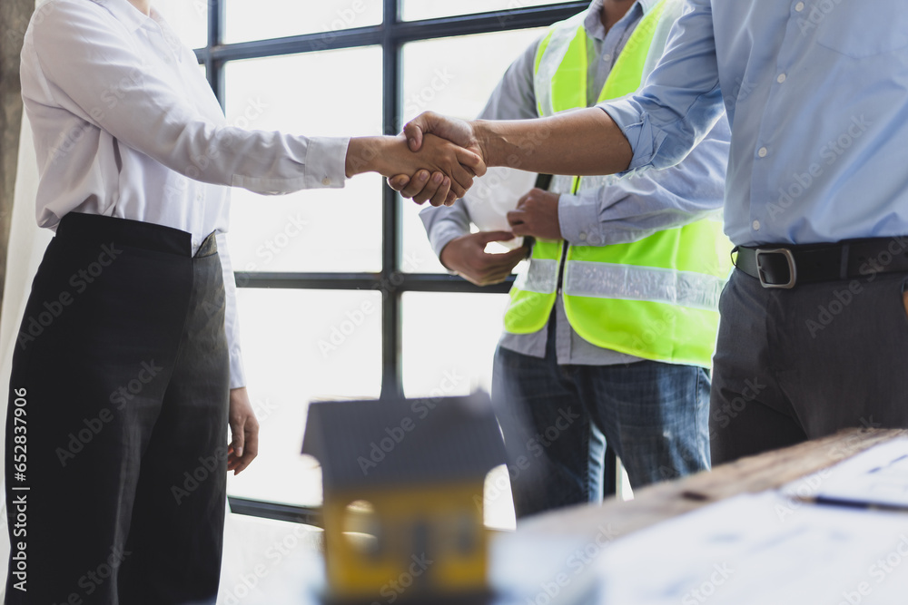 Collaboration of engineers, architects and contractors. Architects hand in hand promote teamwork cooperation of colleagues in construction projects.