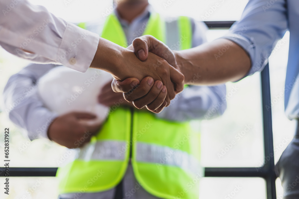 Collaboration of engineers, architects and contractors. Architects hand in hand promote teamwork cooperation of colleagues in construction projects.