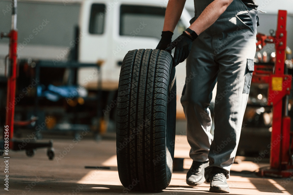 Close up view of moving the wheel. Man is works in the automobile repairing salon