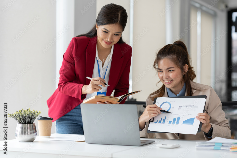 team work process Two asian businesswoman working with laptop computer and discussing documents project idea presentation Analyze the marketing plan. Investment in the office