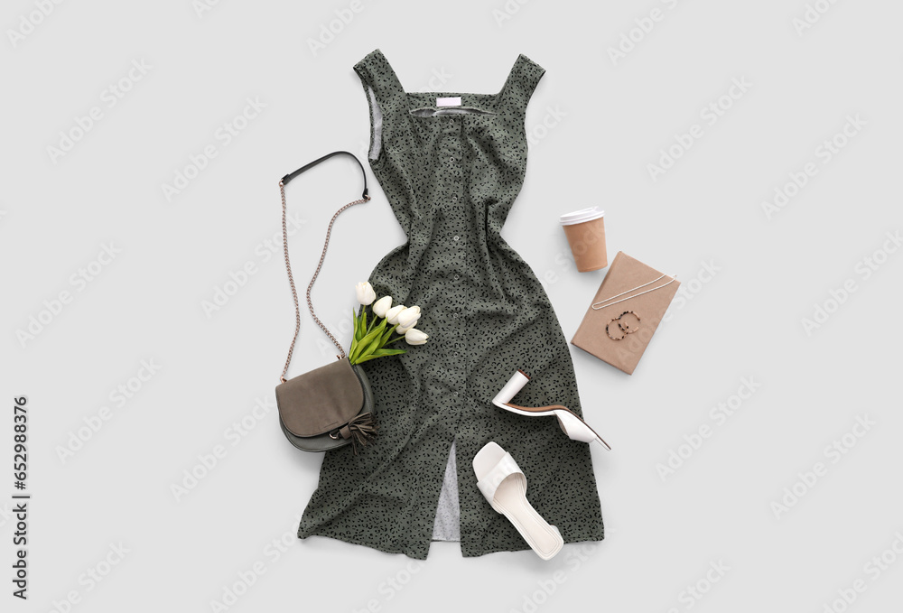 Stylish dress with accessories, shoes, book, tulips and cup of coffee on white background