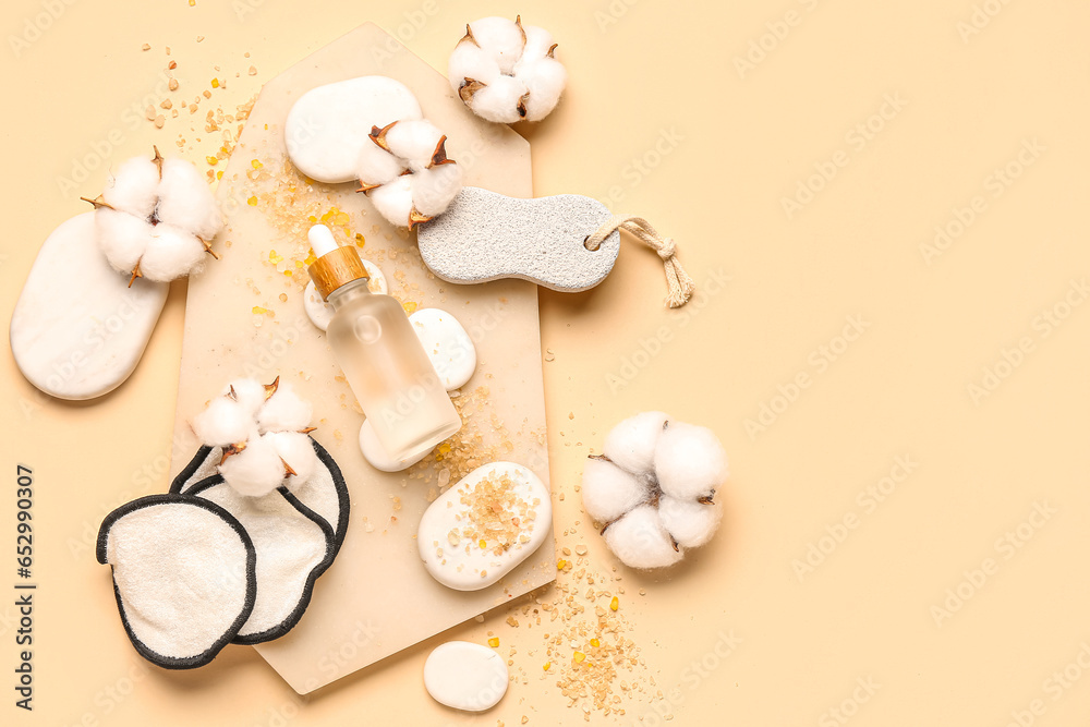 Composition with bottle of essential oil, bath supplies and cotton flowers on color background