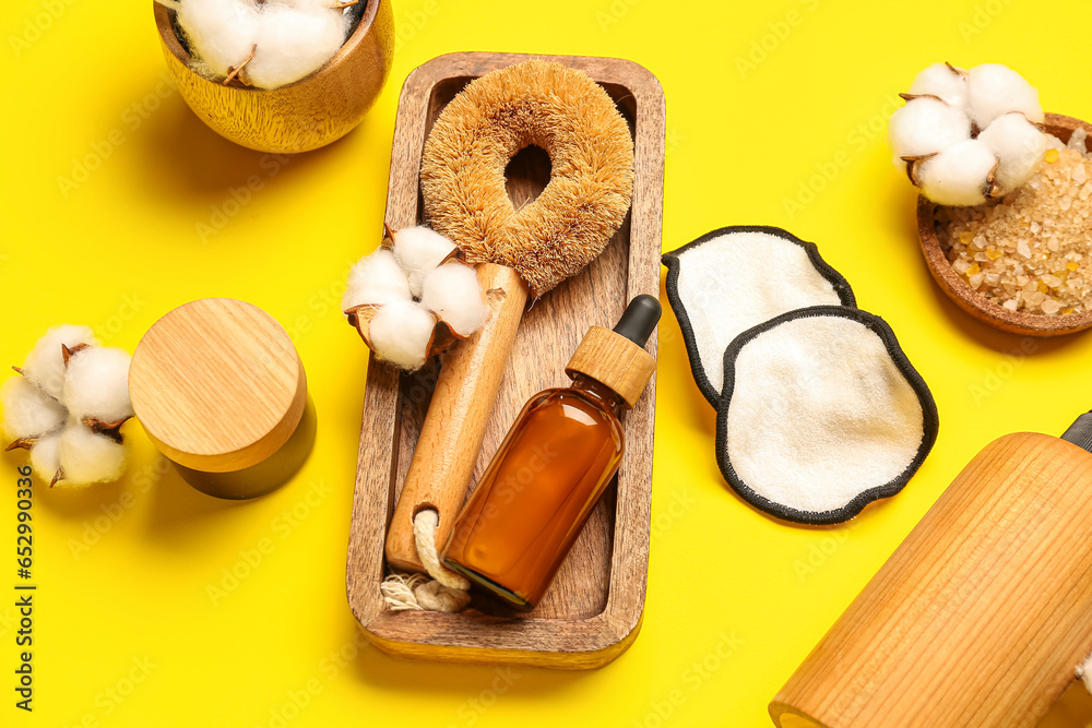 Composition with bath supplies, cosmetics and cotton flowers on yellow background, closeup