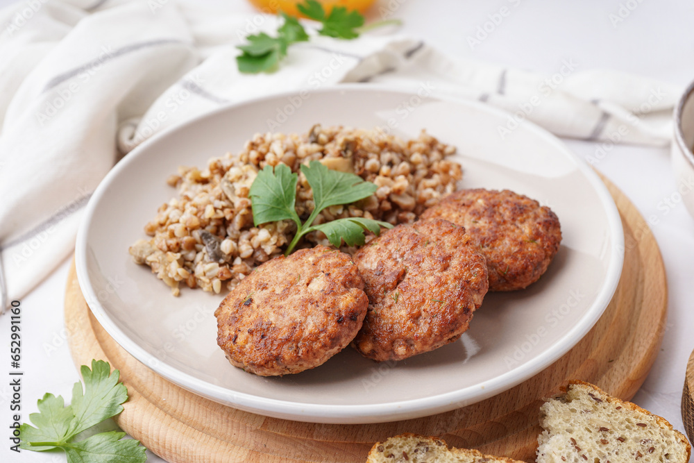 Cutlets with buckwheat, mushrooms and parsley on white table in kitchen