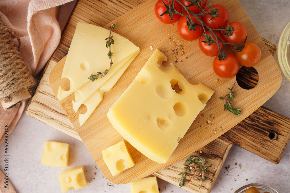 Boards with pieces of Swiss cheese and tomatoes on white table