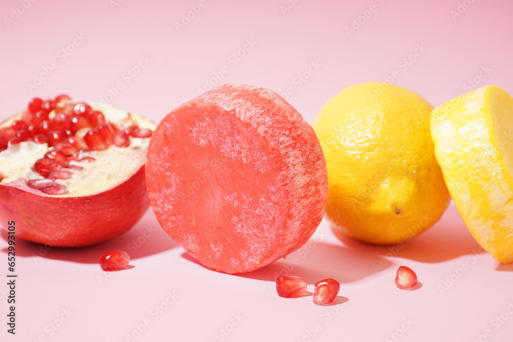 Solid colorful shampoo bars with lemon and pomegranate on pink background