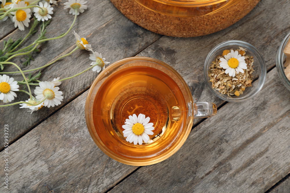 Cup of hot chamomile tea on wooden background