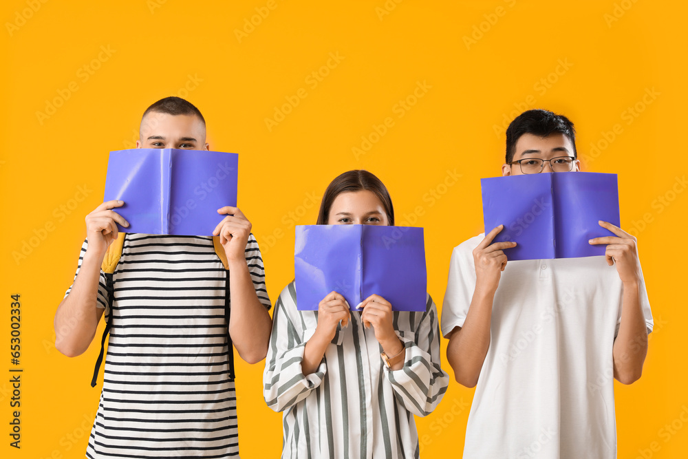 Students with notebooks on yellow background