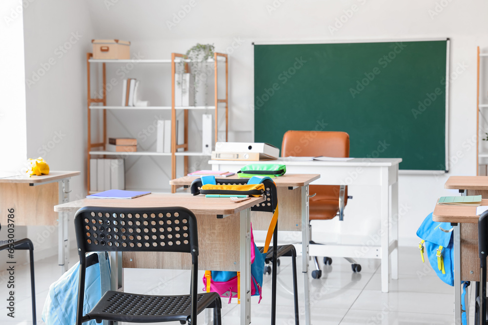 Interior of modern classroom with desks and chairs at school