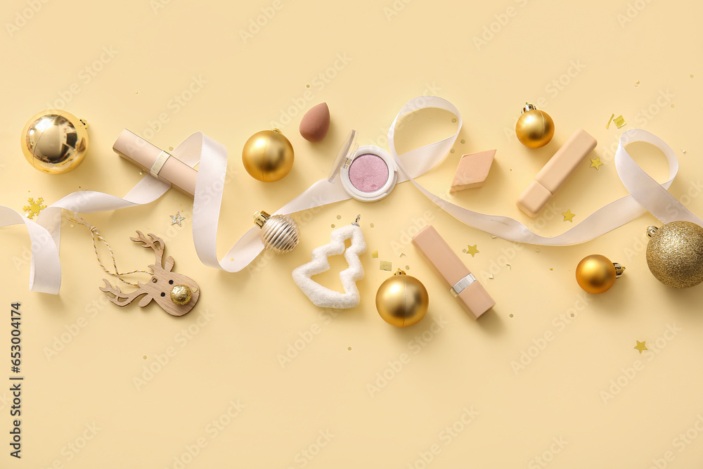 Composition with decorative cosmetics and golden Christmas decor on beige background