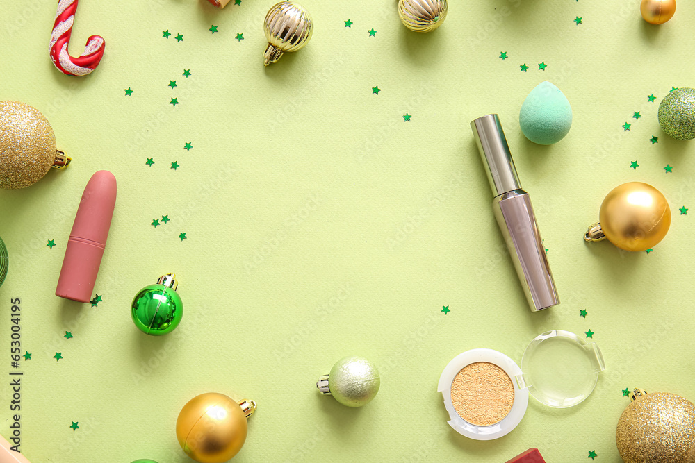 Frame made of decorative cosmetics and Christmas decor on light yellow background