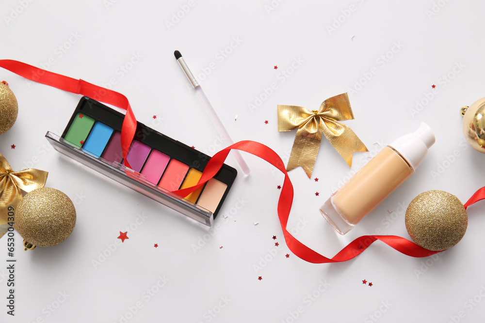 Composition with decorative cosmetics and golden Christmas decor on white background