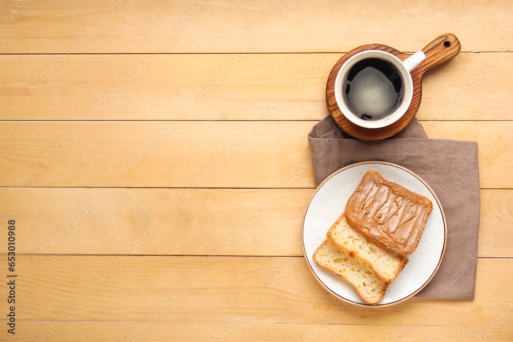 Plate of toasts with peanut butter and cup of coffee on wooden background