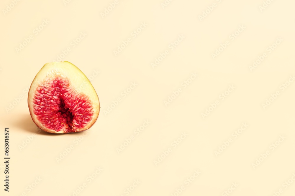 Half of fresh ripe fig on orange background