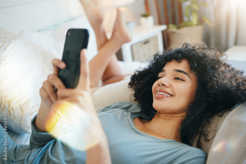 Phone, relax and young woman on a bed networking on social media. mobile app or the internet. Happy, technology and female person from Mexico scroll on cellphone in her bedroom at modern apartment.