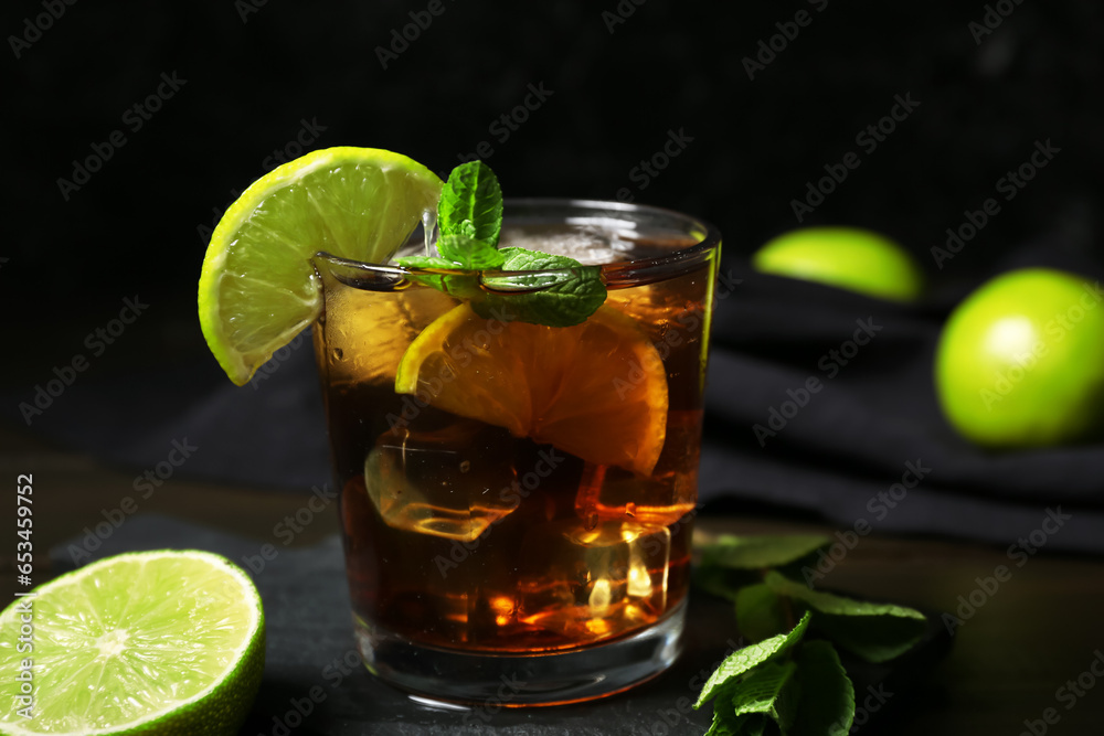 Glass of tasty Cuba Libre cocktail on table, closeup