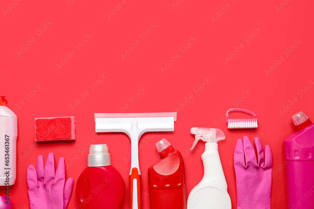 Different cleaning supplies on red background