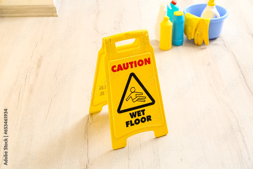 Caution sign on wet floor in room, closeup