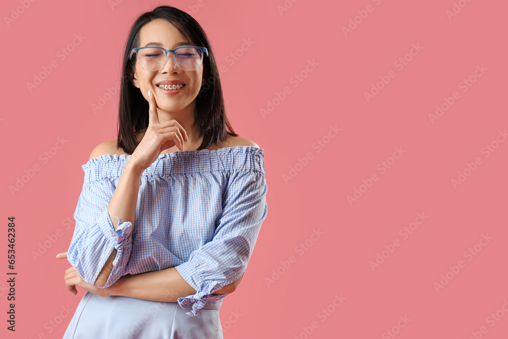 Beautiful Asian woman in stylish eyeglasses on pink background