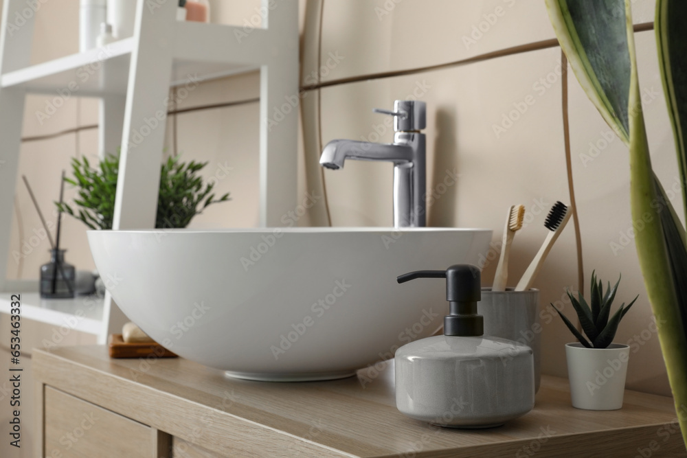 Sink bowl and bath accessories on table in bathroom