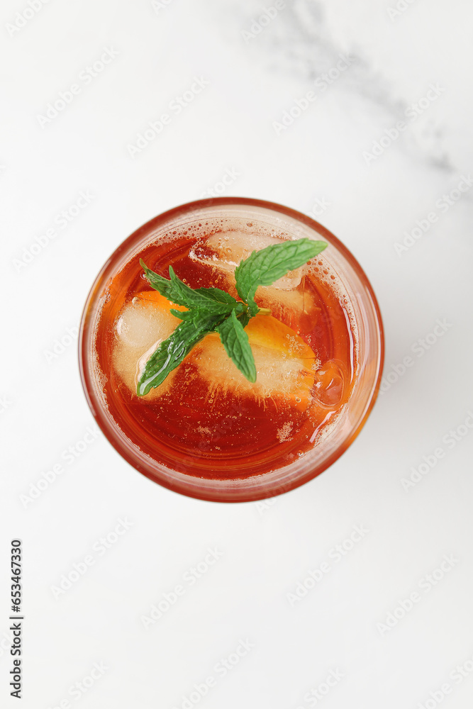 Glass of ice tea with mint on white background