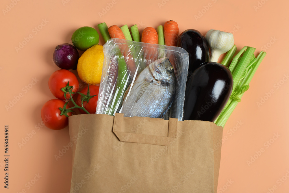 Paper bag with different products on orange background